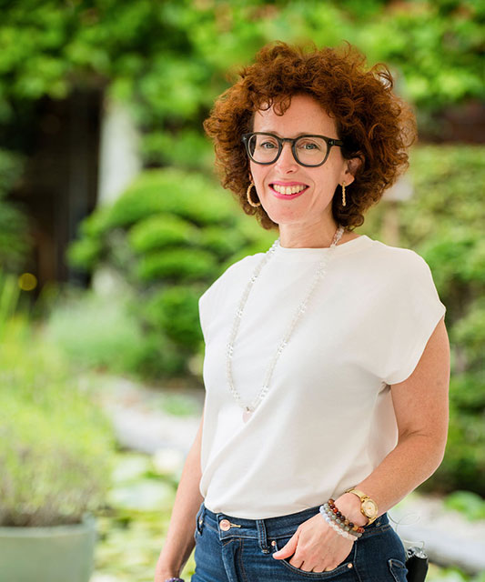 white woman with white tee-shirt hands in trousers pockets