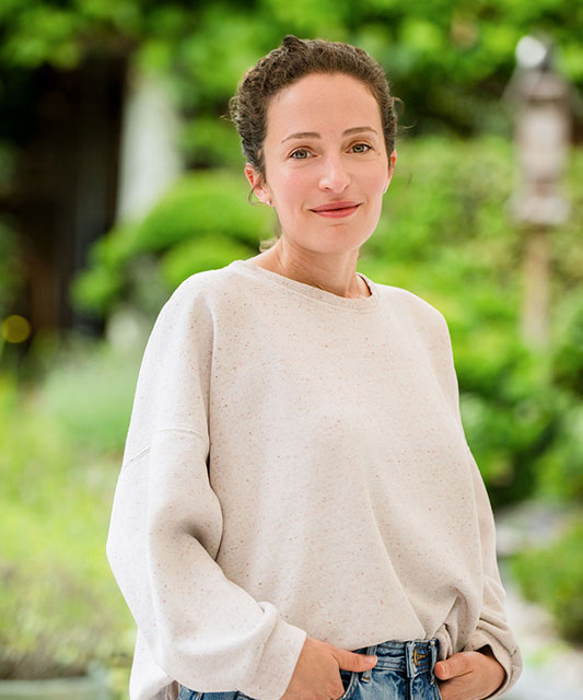 white woman with white shirt hands in trousers pockets